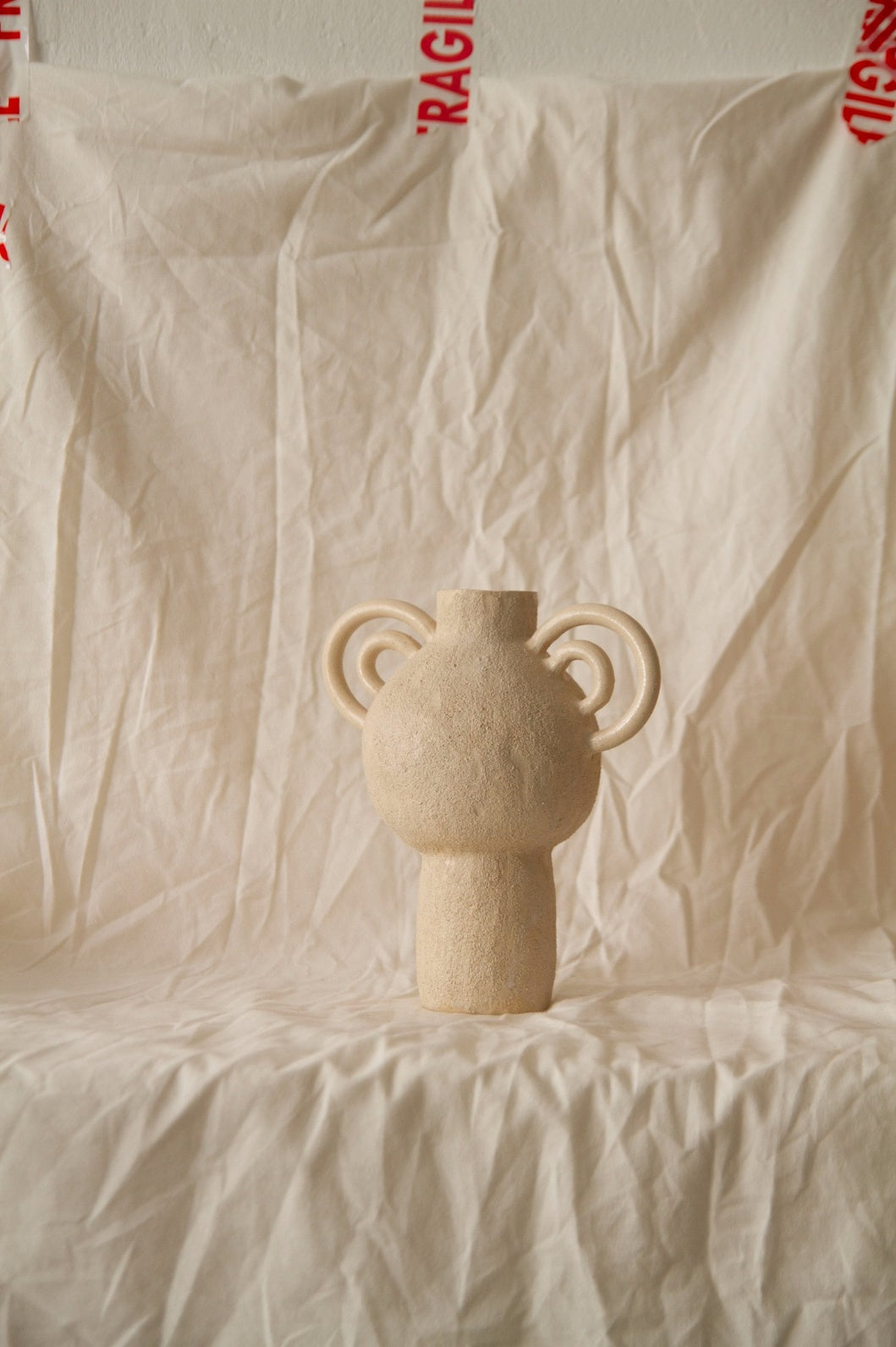 L’Enfant Lune aux Doubles Anses by Clandestine Céramique, handbuilt in sandy clay with double curving handles and soft glaze, part of the House of Woven Stories selection.