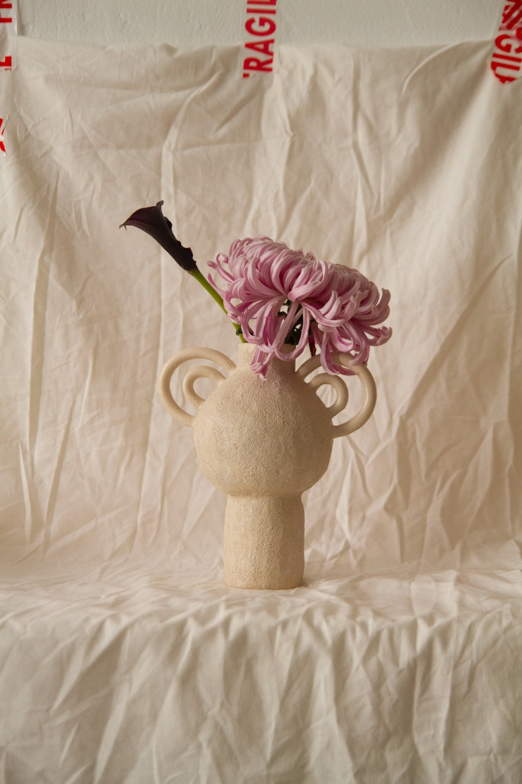 L’Enfant Lune aux Doubles Anses by Clandestine Céramique, handbuilt in sandy clay with double curving handles and soft glaze, part of the House of Woven Stories selection.