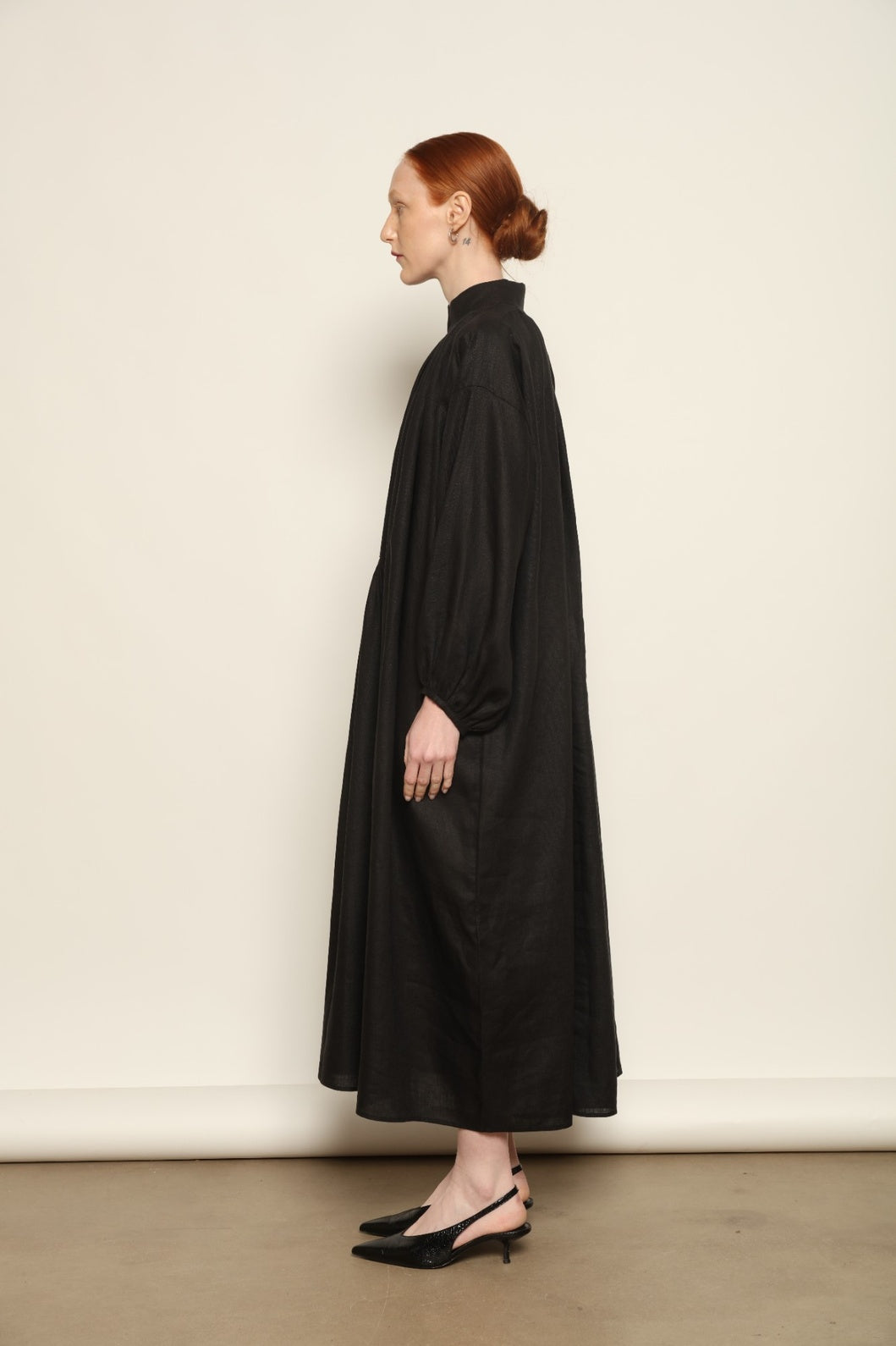 Model is wearing the Les Vacances d’Irina Black Sea Linen Dress, handcrafted from 100% linen with billowing sleeves and a gathered neckline, from the House of Nomad Stories selection.