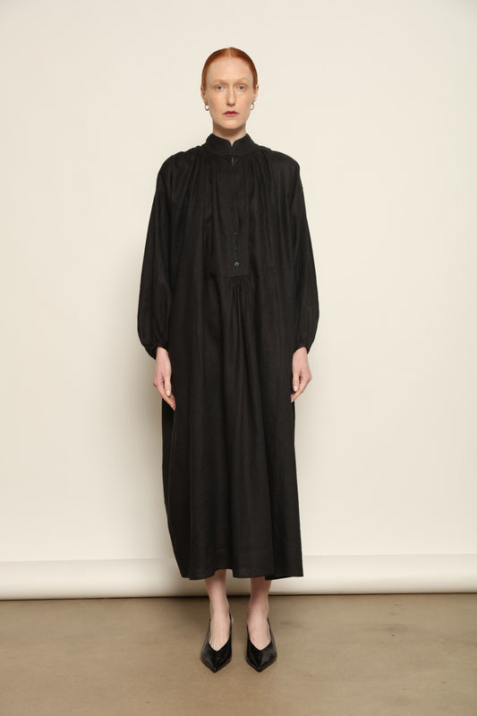 Model is wearing the Les Vacances d’Irina Black Sea Linen Dress, handcrafted from 100% linen with billowing sleeves and a gathered neckline, from the House of Nomad Stories selection.