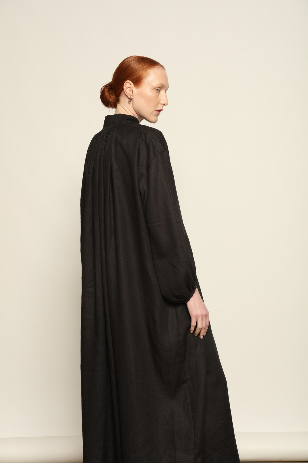 Model is wearing the Les Vacances d’Irina Black Sea Linen Dress, handcrafted from 100% linen with billowing sleeves and a gathered neckline, from the House of Nomad Stories selection.