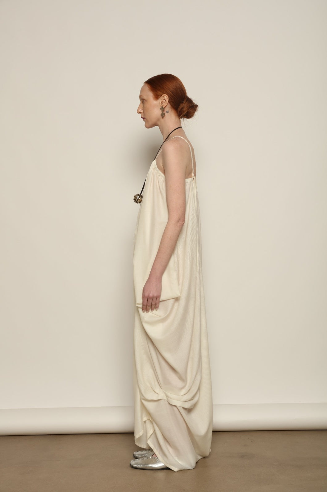 Model is wearing the Les Vacances d’Irina Grande Bellezza Ivory Dress, a sculptural draped full-length dress handcrafted in Bucharest, from the House of Nomad Stories selection.