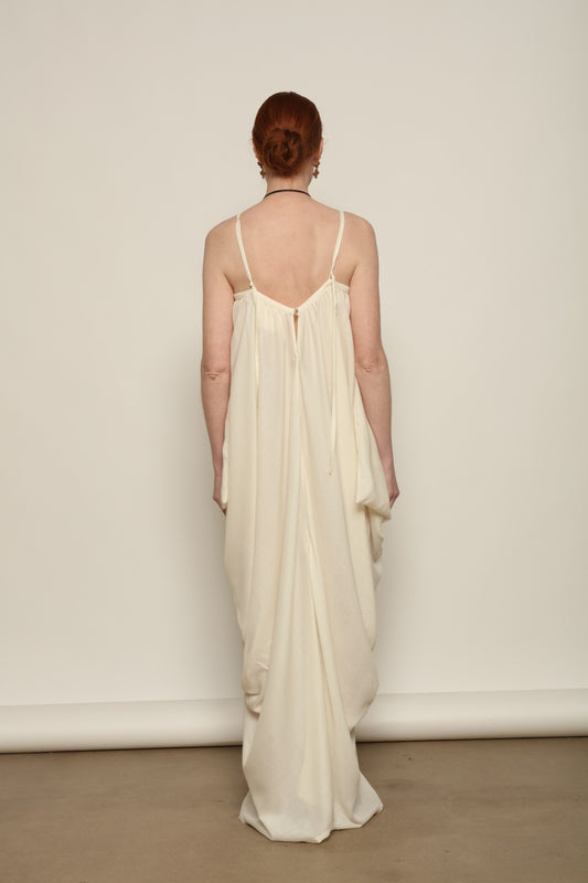 Model is wearing the Les Vacances d’Irina Grande Bellezza Ivory Dress, a sculptural draped full-length dress handcrafted in Bucharest, from the House of Nomad Stories selection.
