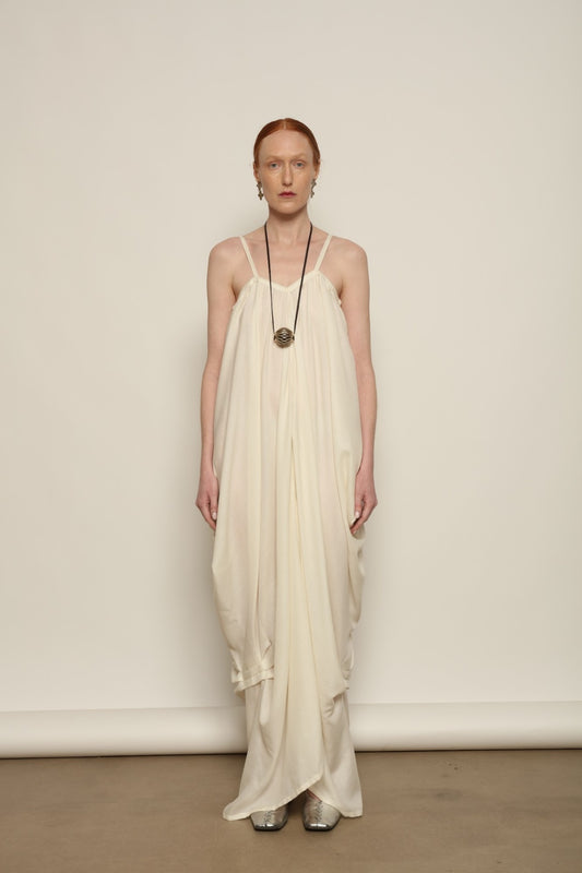 Model is wearing the Les Vacances d’Irina Grande Bellezza Ivory Dress, a sculptural draped full-length dress handcrafted in Bucharest, from the House of Nomad Stories selection.
