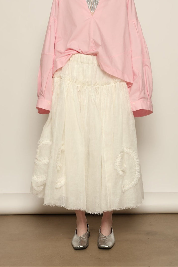 Model is wearing the Les Vacances d’Irina Shell White Skirt, handcrafted from linen with voluminous silhouette and hand-applied ruffles, from the House of Nomad Stories selection.
