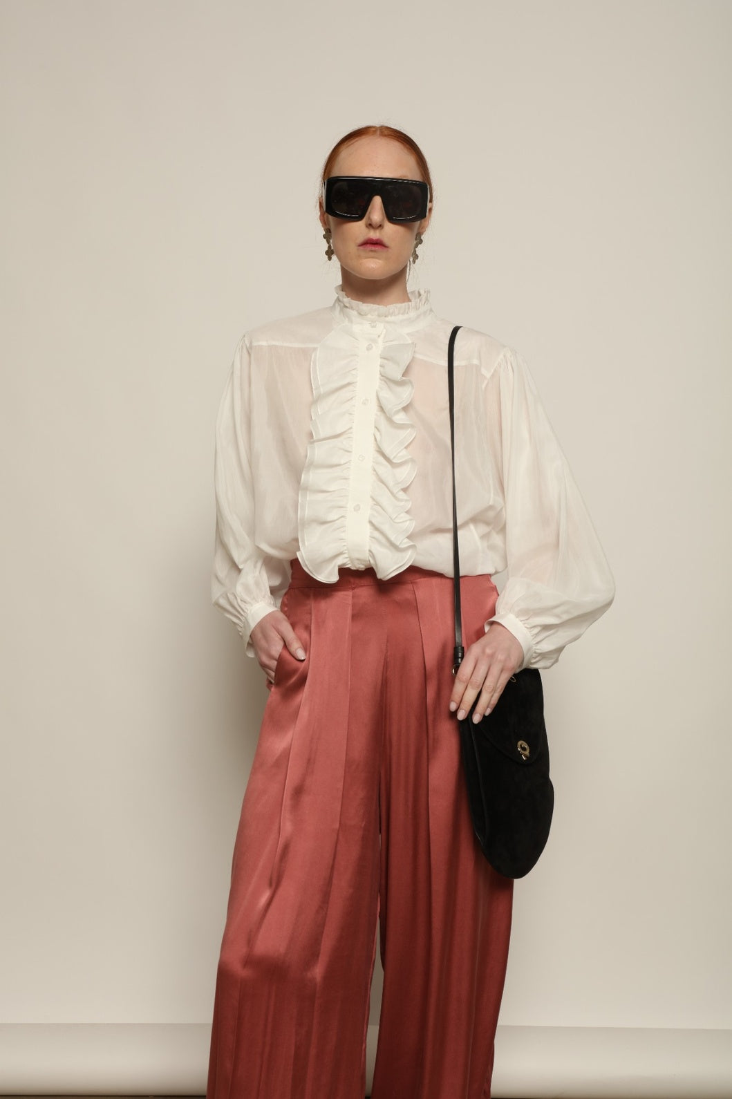 Model is wearing the Les Vacances d’Irina Victorian White Blouse with ruffled collar, front frills and voluminous sleeves, handcrafted in Bucharest, from the House of Nomad Stories selection.