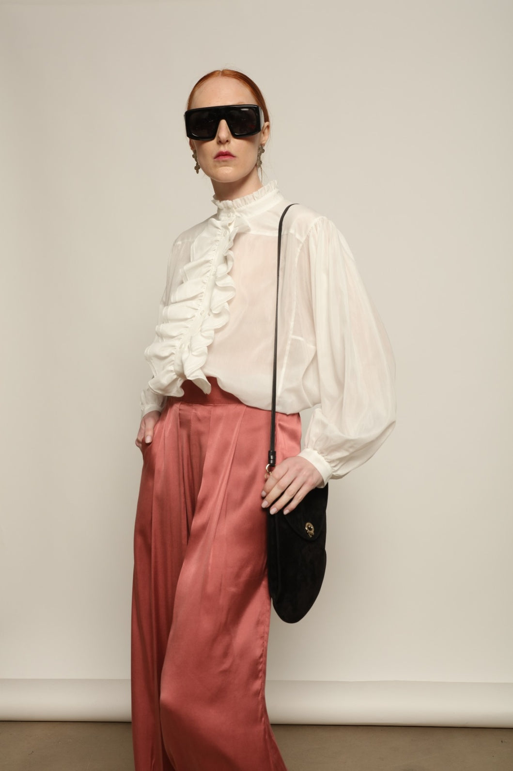 Model is wearing the Les Vacances d’Irina Victorian White Blouse with ruffled collar, front frills and voluminous sleeves, handcrafted in Bucharest, from the House of Nomad Stories selection.