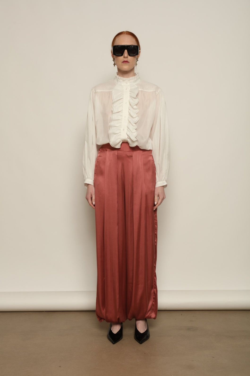 Model is wearing the Les Vacances d’Irina Victorian White Blouse with ruffled collar, front frills and voluminous sleeves, handcrafted in Bucharest, from the House of Nomad Stories selection.