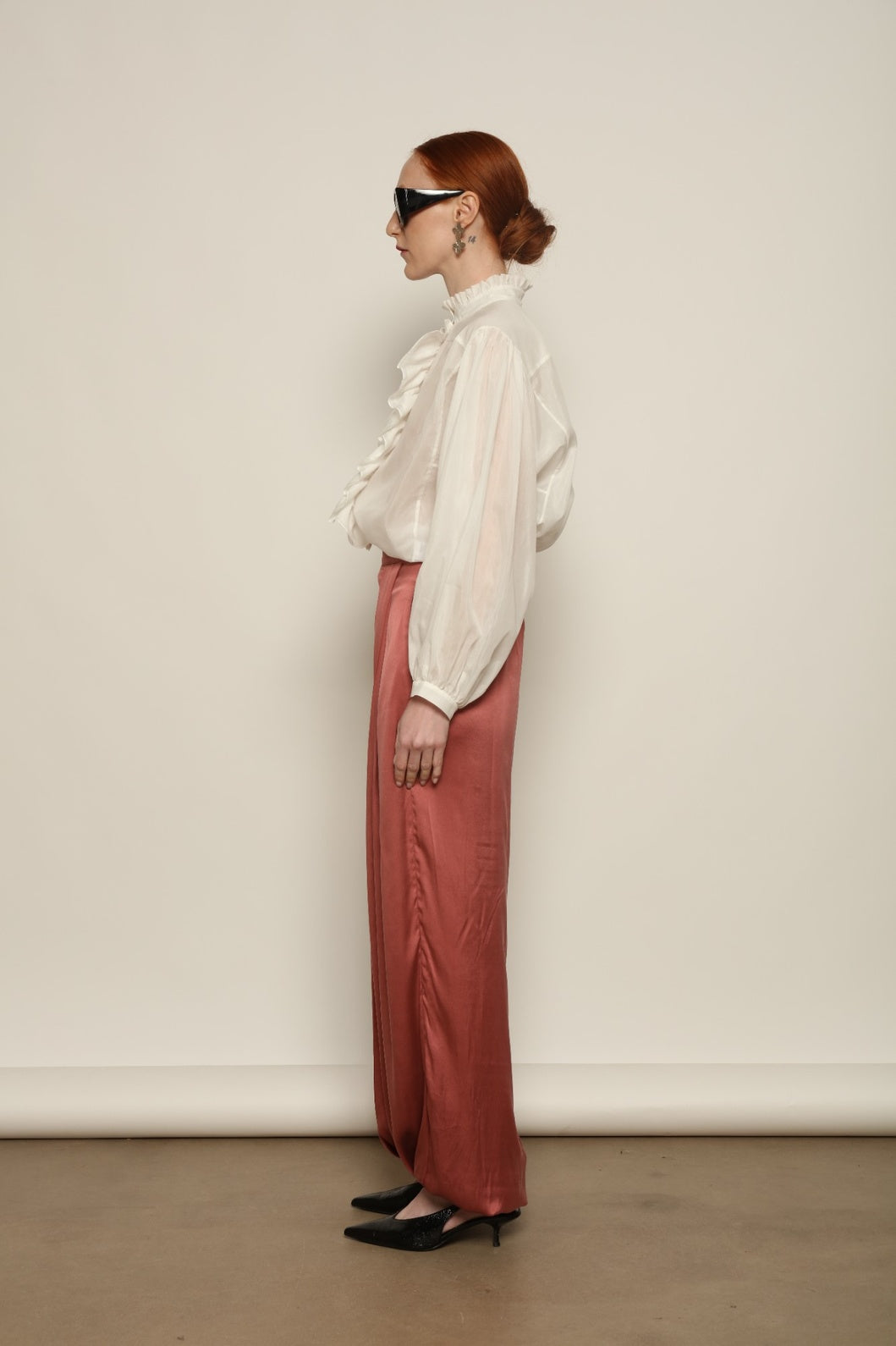 Model is wearing the Les Vacances d’Irina Victorian White Blouse with ruffled collar, front frills and voluminous sleeves, handcrafted in Bucharest, from the House of Nomad Stories selection.