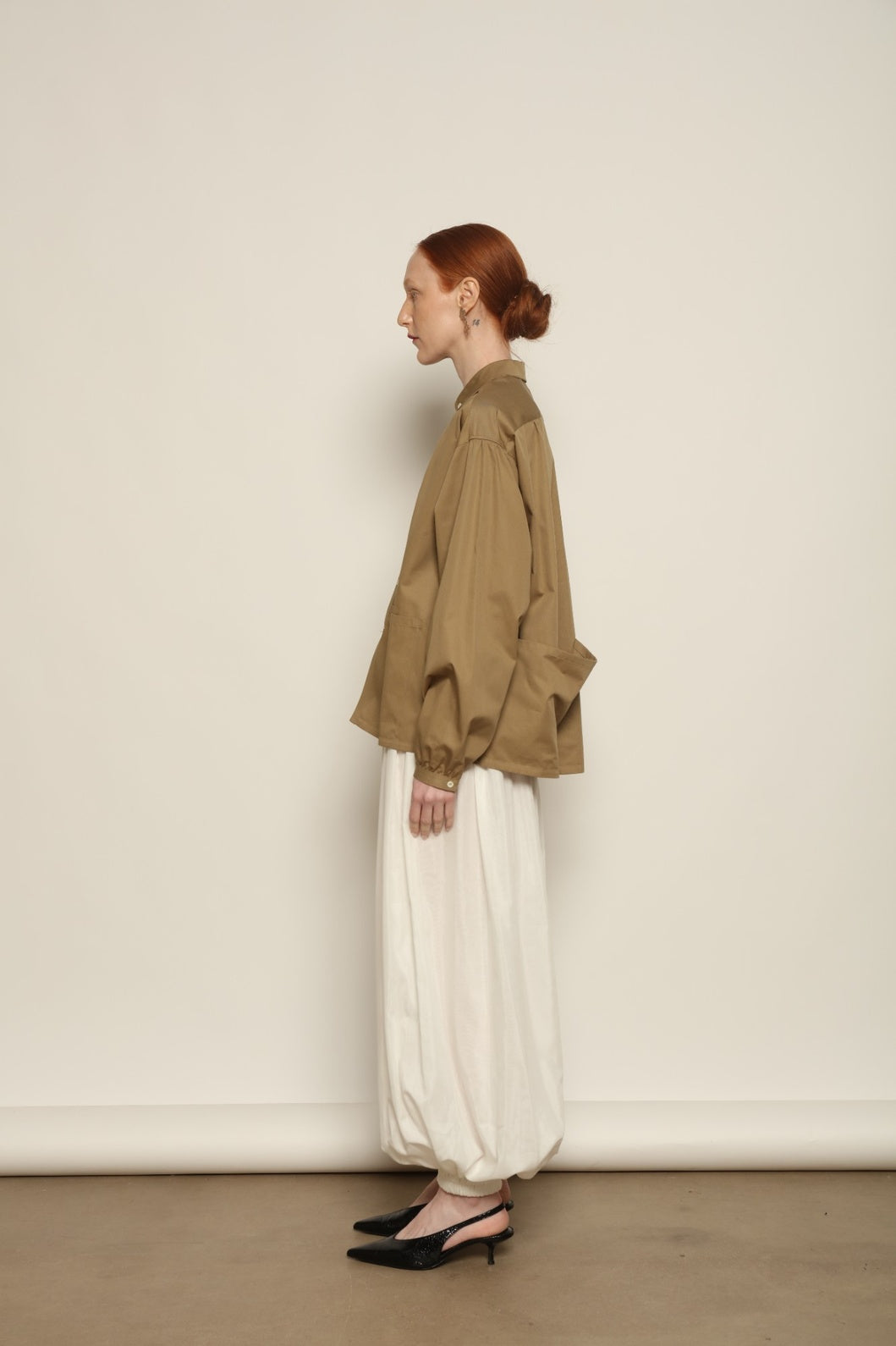 Model is wearing the Les Vacances d’Irina Vulcano White Pants, handcrafted from 100% cotton with a balloon silhouette and gathered ankles, from the House of Nomad Stories selection.