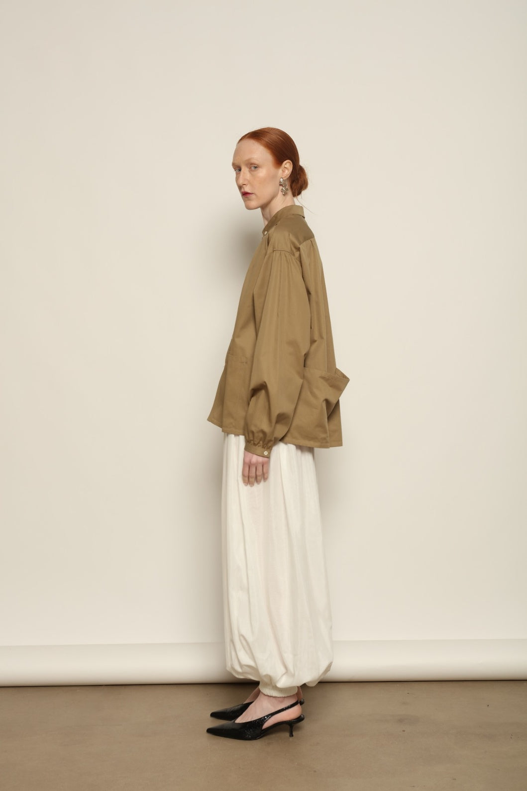Model is wearing the Les Vacances d’Irina Vulcano White Pants, handcrafted from 100% cotton with a balloon silhouette and gathered ankles, from the House of Nomad Stories selection.
