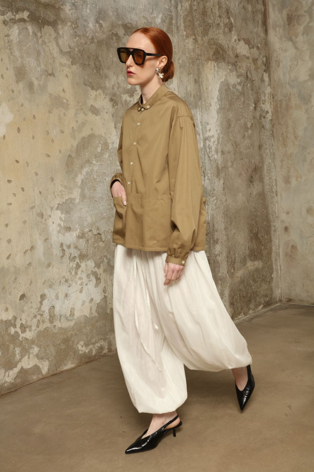 Model is wearing the Les Vacances d’Irina Vulcano White Pants, handcrafted from 100% cotton with a balloon silhouette and gathered ankles, from the House of Nomad Stories selection.