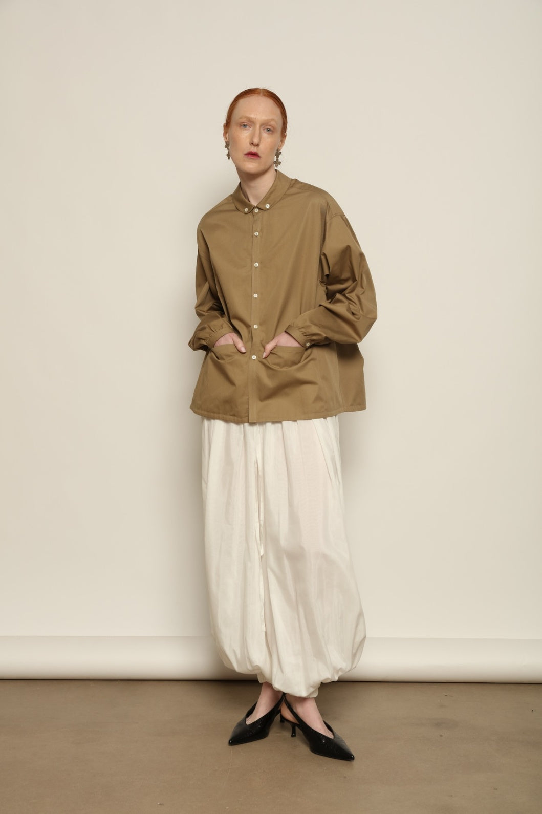 Model is wearing the Les Vacances d’Irina Vulcano White Pants, handcrafted from 100% cotton with a balloon silhouette and gathered ankles, from the House of Nomad Stories selection.