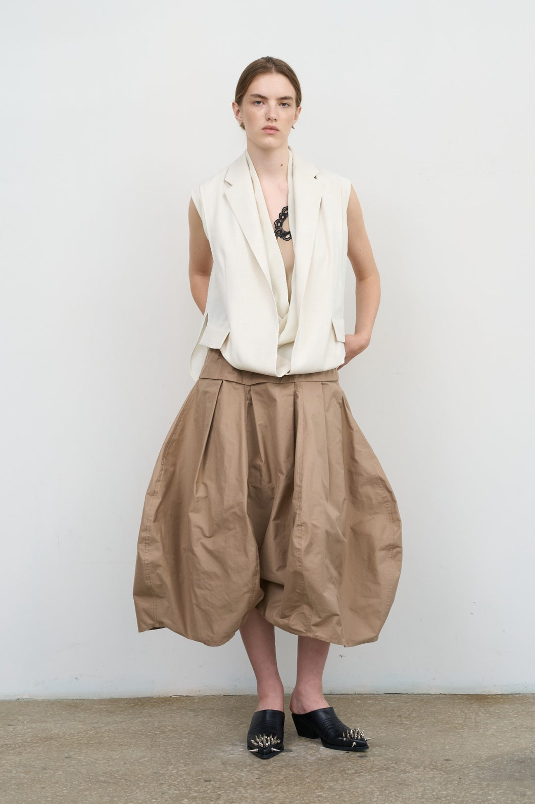 Model is wearing Litkovska beige ruffled midi skirt with pleated waist and voluminous balloon hem. A sculptural, modern, and artisanal piece that belongs to the curated selection of House of Nomad Stories.