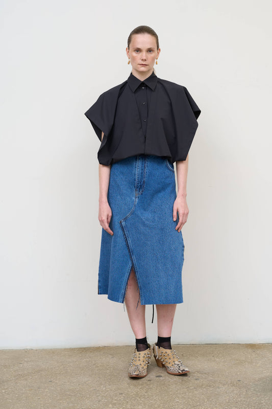 Model is wearing a deconstructed black wool-blend sleeveless shirt by Litkovska with architectural tailoring and elongated silhouette, designer women’s shirt available at House of Woven Stories