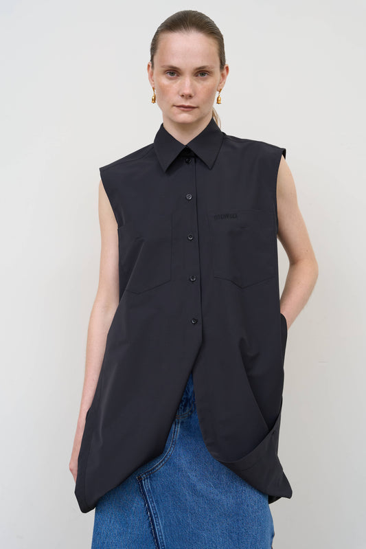 Model is wearing a deconstructed black wool-blend sleeveless shirt by Litkovska with architectural tailoring and elongated silhouette, designer women’s shirt available at House of Woven Stories