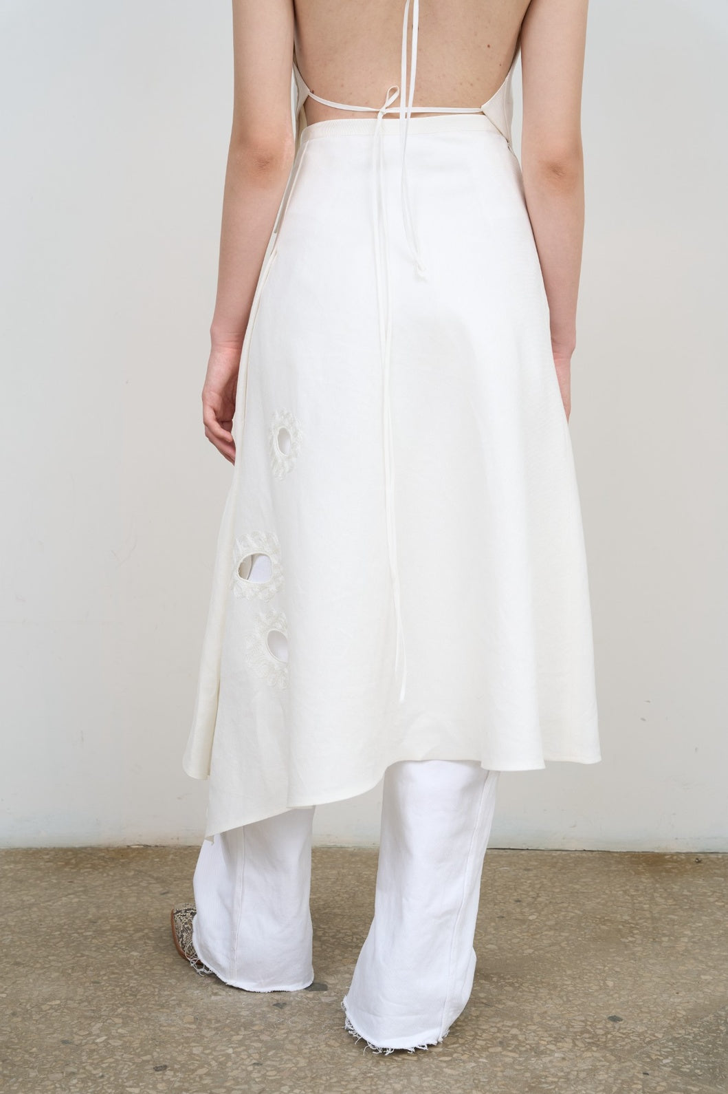 Model is wearing Litkovska white midi skirt with floral appliqué, crisp poplin, and balloon silhouette. A modern, sculptural, and artisanal piece that belongs to the curated selection of House of Nomad Stories.