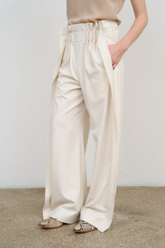 Model is wearing Litkovska high-rise pleated wide-leg ivory pants with tailored pleats and fluid silhouette. A modern, architectural, and timeless piece that belongs to the curated selection of House of Nomad Stories.