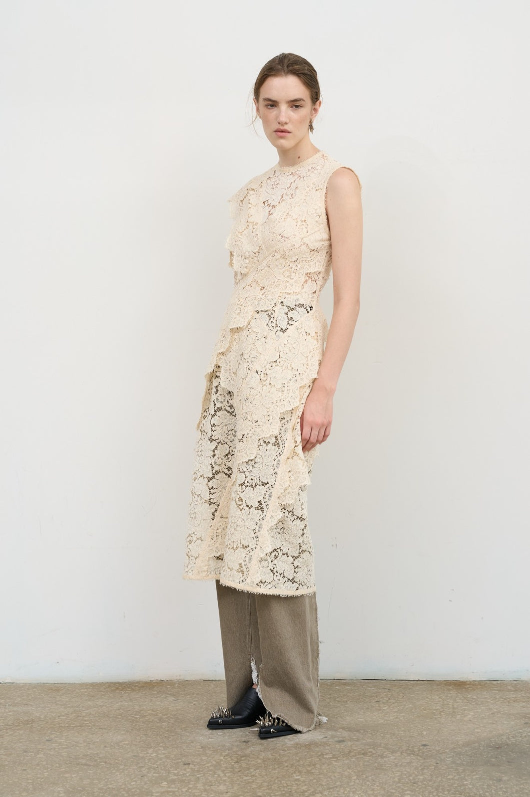 Model is wearing Litkovska ivory lace overlay midi dress with layered ruffles and high neck, a contemporary artisanal design that belongs to the curated selection of House of Nomad Stories.