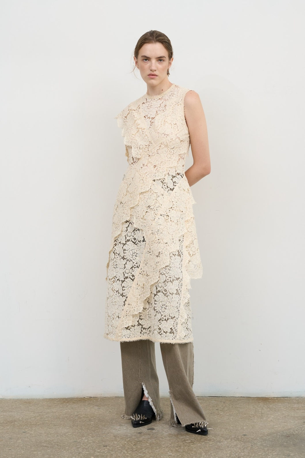Model is wearing Litkovska ivory lace overlay midi dress with layered ruffles and high neck, a contemporary artisanal design that belongs to the curated selection of House of Nomad Stories.