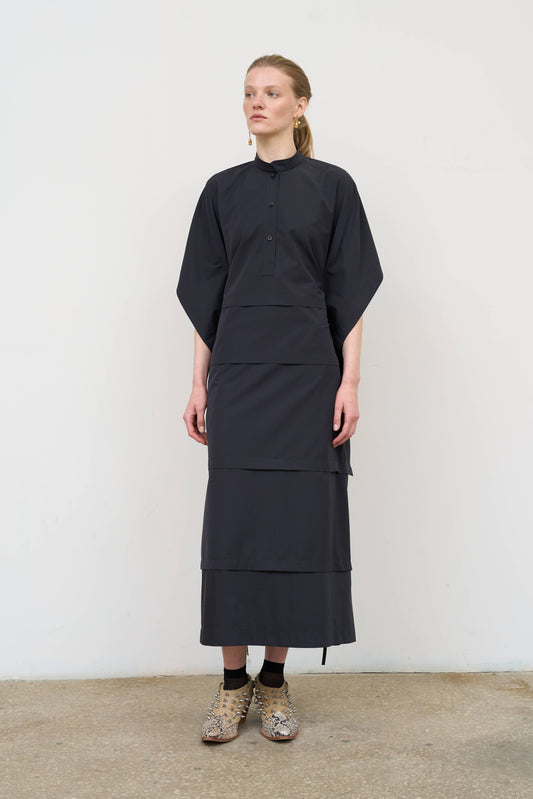 Model is wearing a midi dress by Litkovska with capelet detail, layered wool-blend structure and cotton elements, designer women’s dress available at House of Woven Stories