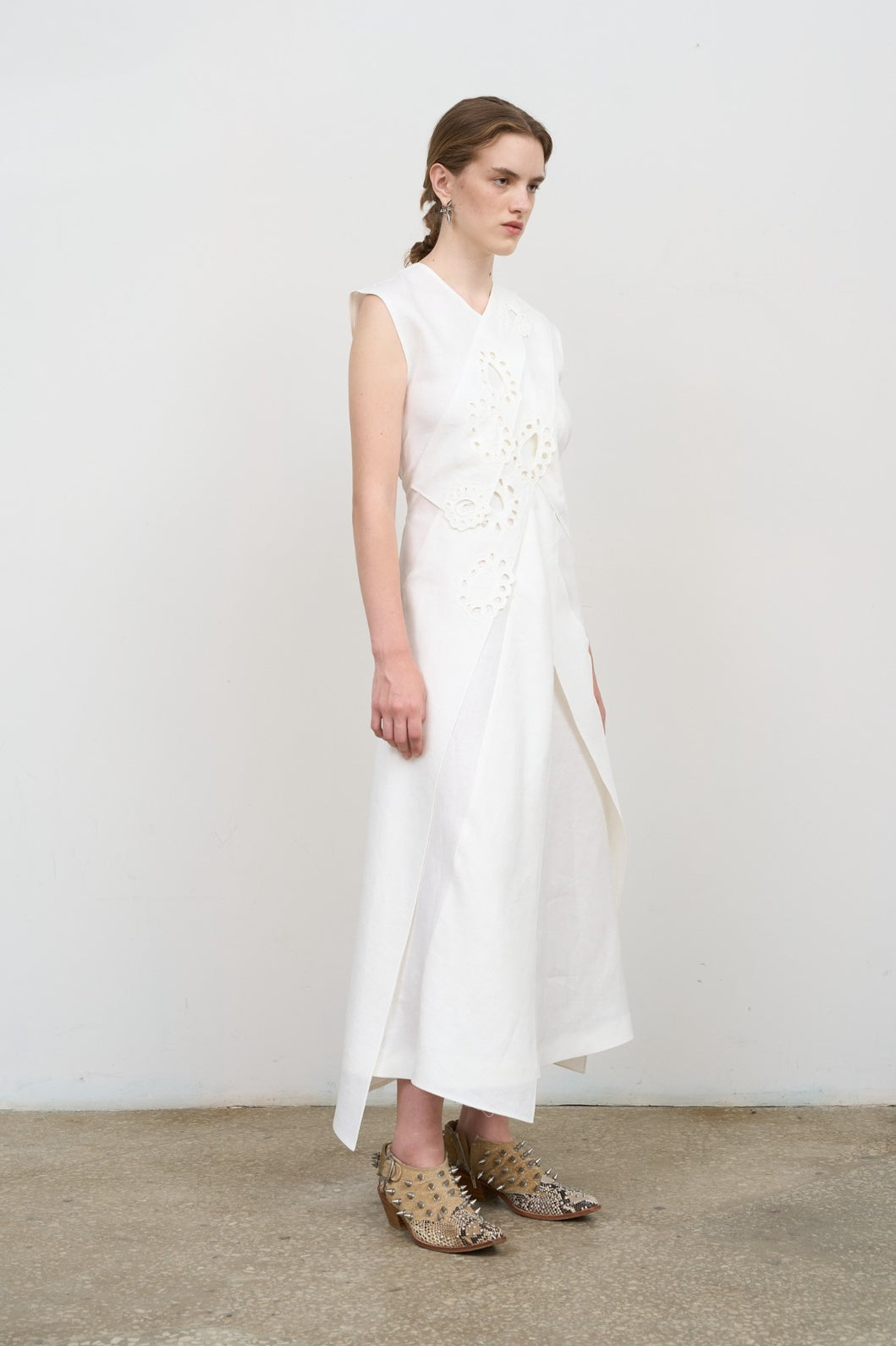 Model is wearing Litkovska white layered midi dress with deep V-neck, sleeveless silhouette, and floral embroidery. A refined, modern, and artisanal piece that belongs to the curated selection of House of Nomad Stories.