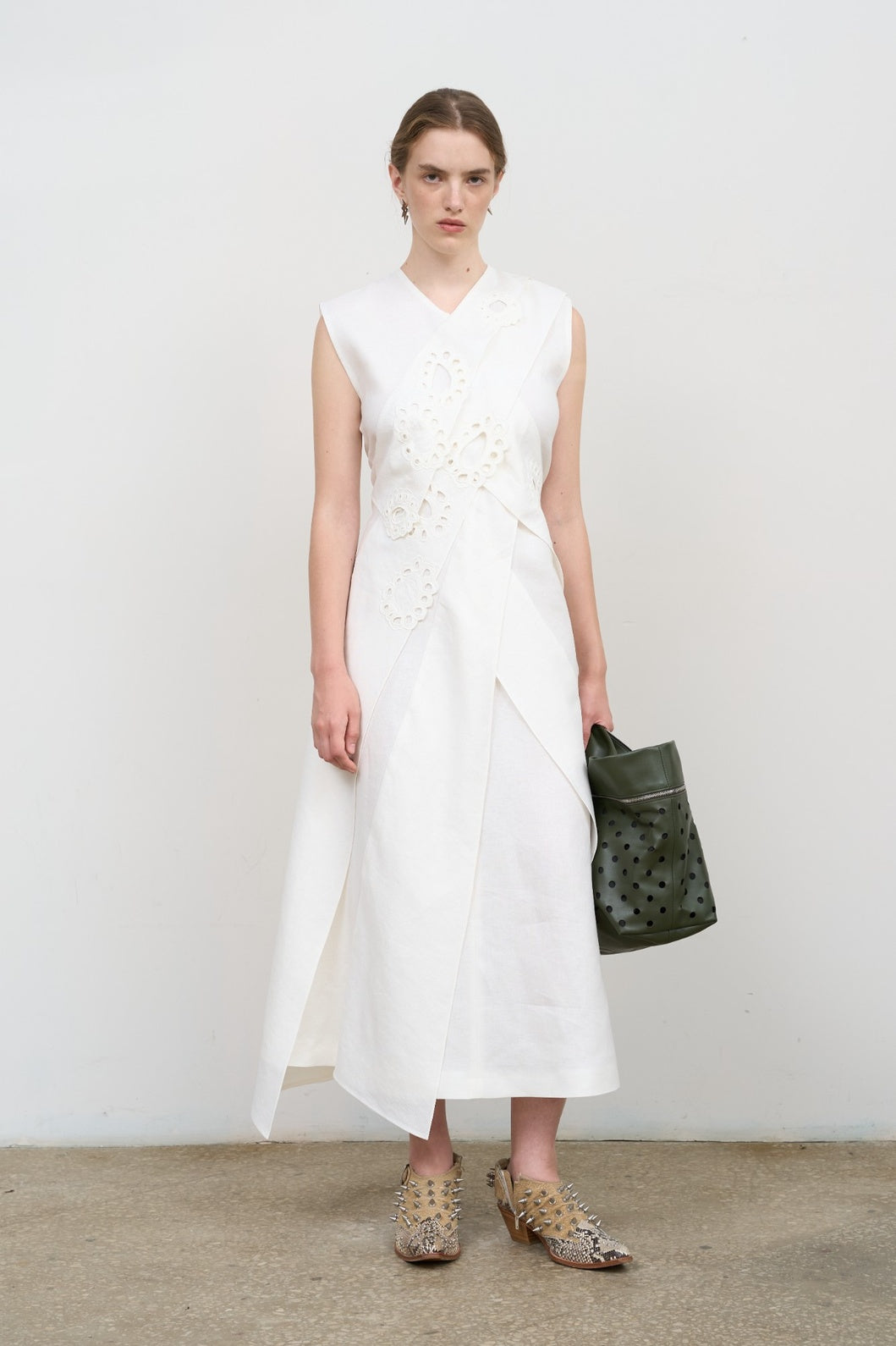 Model is wearing Litkovska white layered midi dress with deep V-neck, sleeveless silhouette, and floral embroidery. A refined, modern, and artisanal piece that belongs to the curated selection of House of Nomad Stories.