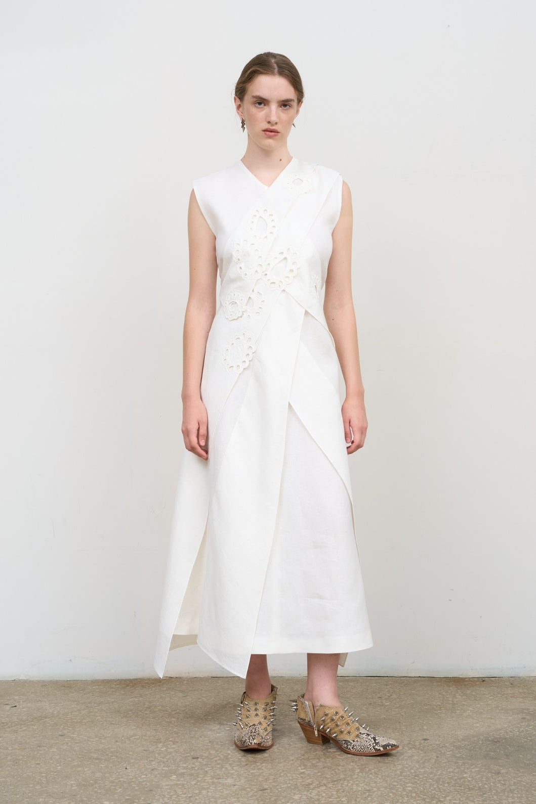 Model is wearing Litkovska white layered midi dress with deep V-neck, sleeveless silhouette, and floral embroidery. A refined, modern, and artisanal piece that belongs to the curated selection of House of Nomad Stories.
