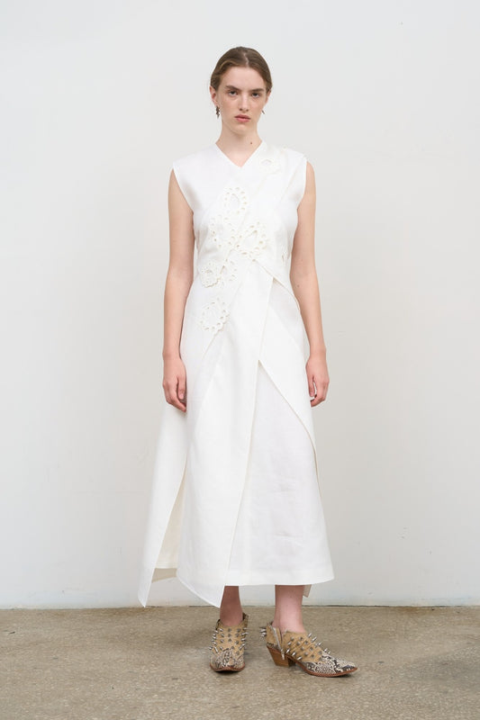 Model is wearing Litkovska white layered midi dress with deep V-neck, sleeveless silhouette, and floral embroidery. A refined, modern, and artisanal piece that belongs to the curated selection of House of Nomad Stories.