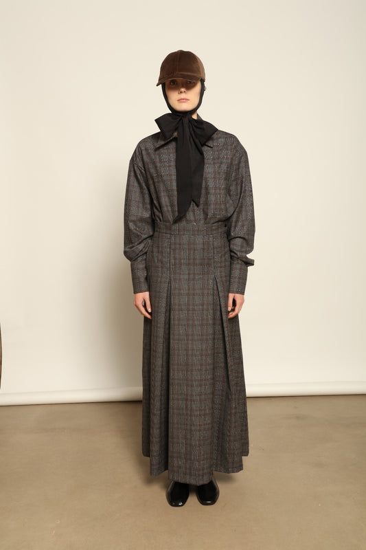 Model is wearing the Londra Brown Checked Skirt by House of Woven Stories, ankle-length with fine pleats and brown checked pattern, combining timeless tailoring with contemporary elegance and quality craftsmanship.