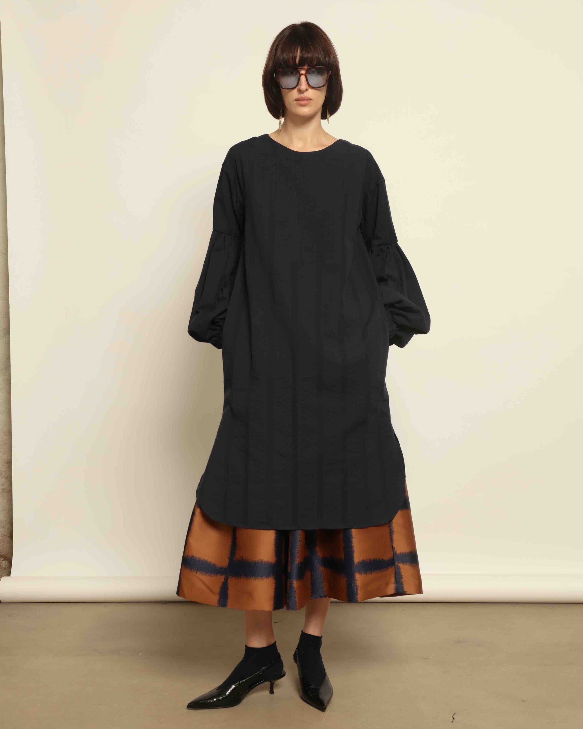 Model is wearing the Lulu Dress by House of Woven Stories in navy blue with voluminous sleeves, A-line silhouette.