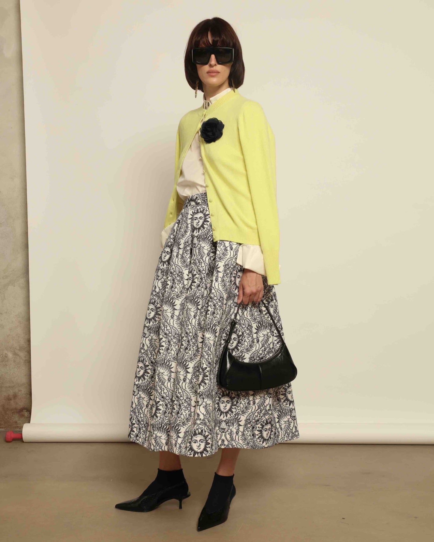 Model is wearing Sun Black and White Skirt by Lunatica Milano. Romantic floral skirt in classic black and white. Elegant, feminine, and handcrafted in Italy. Part of House of Woven Stories selection.