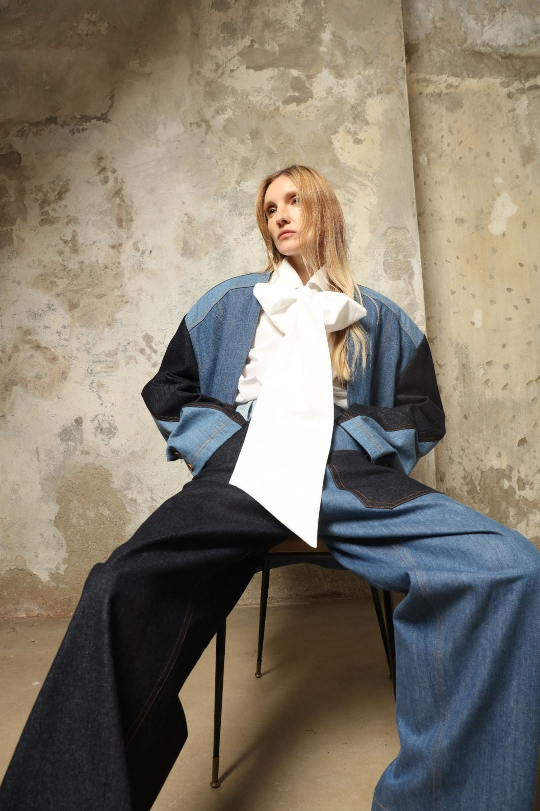 Model is wearing the Carla Denim Patchwork Pant by Maison Jejia, tailored denim trousers crafted from mixed-wash patches with a relaxed structured silhouette and fine stitching, curated in the House of Woven Stories selection