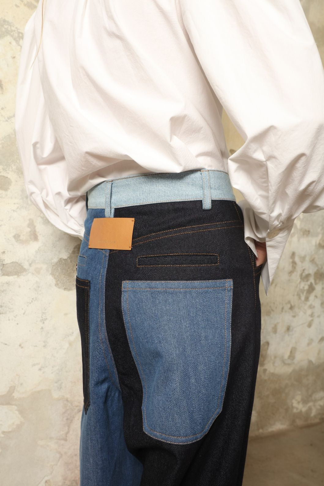 Model is wearing the Carla Denim Patchwork Pant by Maison Jejia, tailored denim trousers crafted from mixed-wash patches with a relaxed structured silhouette and fine stitching, curated in the House of Woven Stories selection