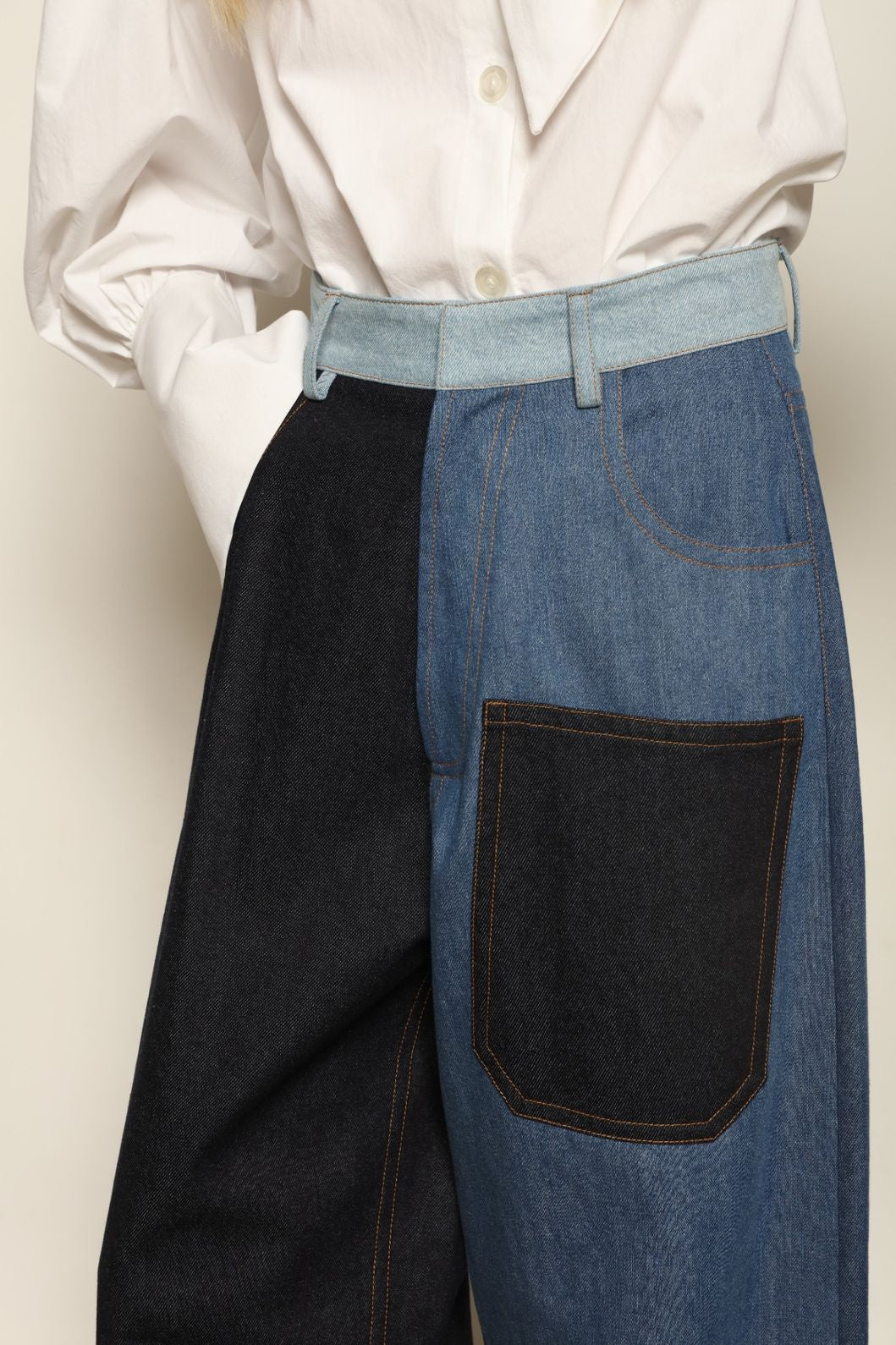 Model is wearing the Carla Denim Patchwork Pant by Maison Jejia, tailored denim trousers crafted from mixed-wash patches with a relaxed structured silhouette and fine stitching, curated in the House of Woven Stories selection