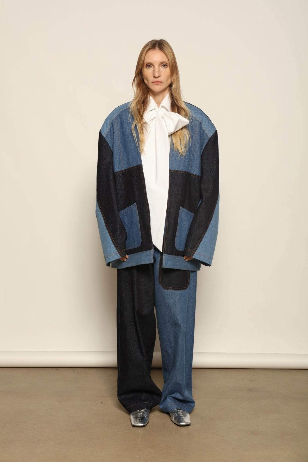 Model is wearing the Jonathan Denim Patchwork Blazer by Maison Jejia, an artisanal tailored blazer made from mixed-wash denim panels with sculpted shoulders and a relaxed sharp silhouette, curated in the House of Woven Stories selection