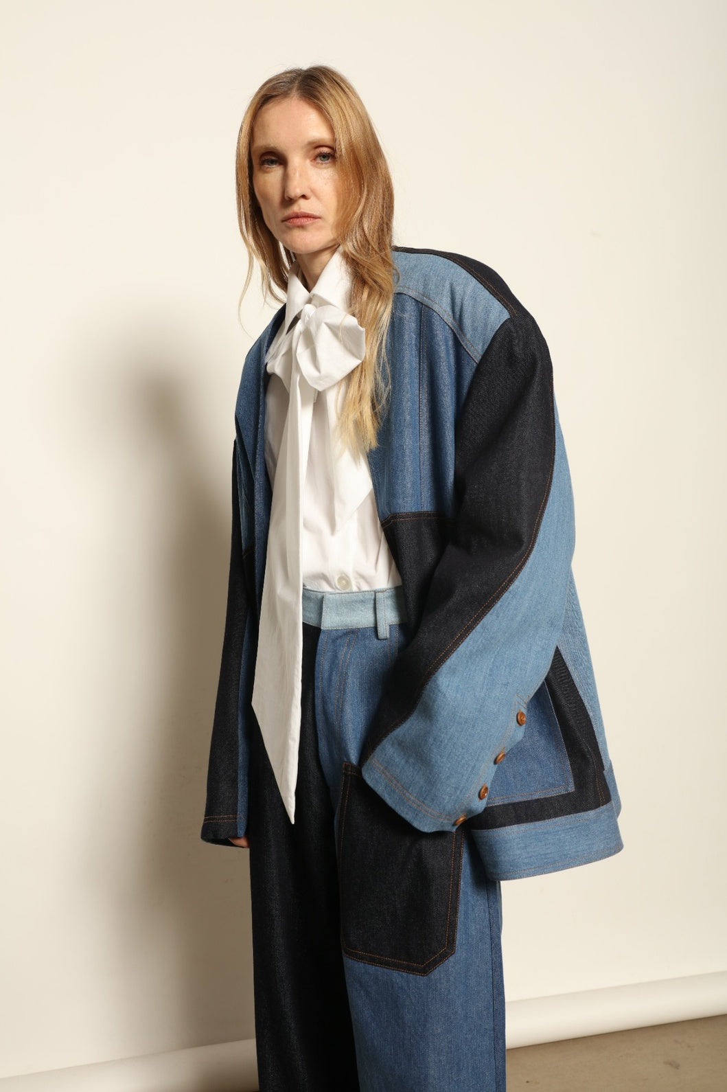 Model is wearing the Jonathan Denim Patchwork Blazer by Maison Jejia, an artisanal tailored blazer made from mixed-wash denim panels with sculpted shoulders and a relaxed sharp silhouette, curated in the House of Woven Stories selection