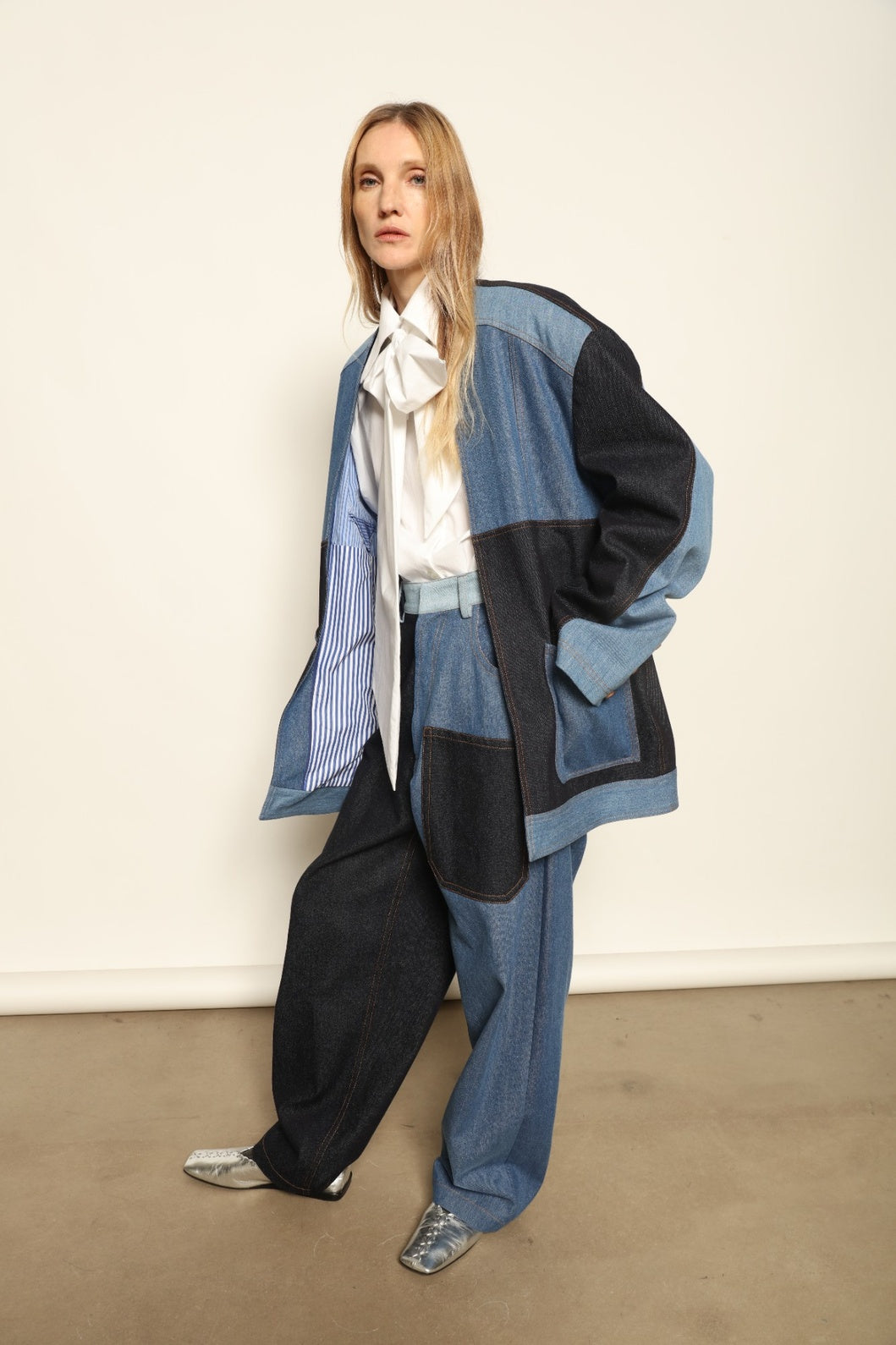 Model is wearing the Jonathan Denim Patchwork Blazer by Maison Jejia, an artisanal tailored blazer made from mixed-wash denim panels with sculpted shoulders and a relaxed sharp silhouette, curated in the House of Woven Stories selection