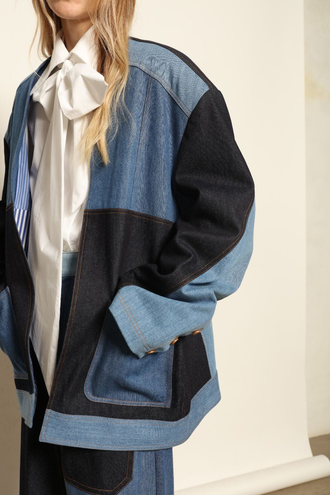 Model is wearing the Jonathan Denim Patchwork Blazer by Maison Jejia, an artisanal tailored blazer made from mixed-wash denim panels with sculpted shoulders and a relaxed sharp silhouette, curated in the House of Woven Stories selection