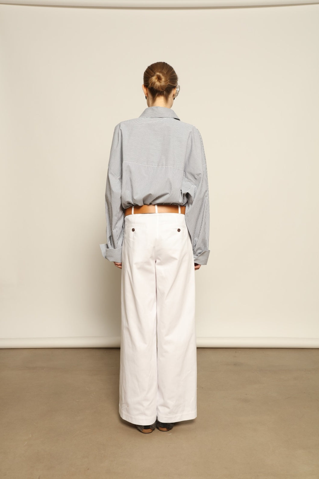 Model is wearing the Katherine White A-Line Pant by Maison Jejia, structured cotton trousers with an elongating A-line silhouette, curated in the House of Woven Stories selection.