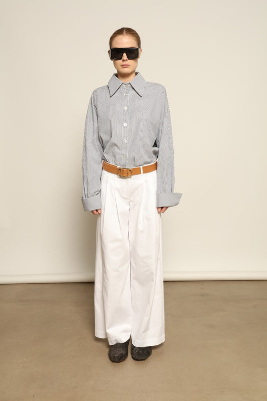 Model is wearing the Katherine White A-Line Pant by Maison Jejia, structured cotton trousers with an elongating A-line silhouette, curated in the House of Woven Stories selection.