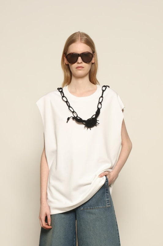 Model is wearing the Tea Cotton Jersey T-Shirt with Black Crab by Maison Jejia, a relaxed cotton tee featuring a playful beaded crab necklace detail, curated in the House of Woven Stories selection.