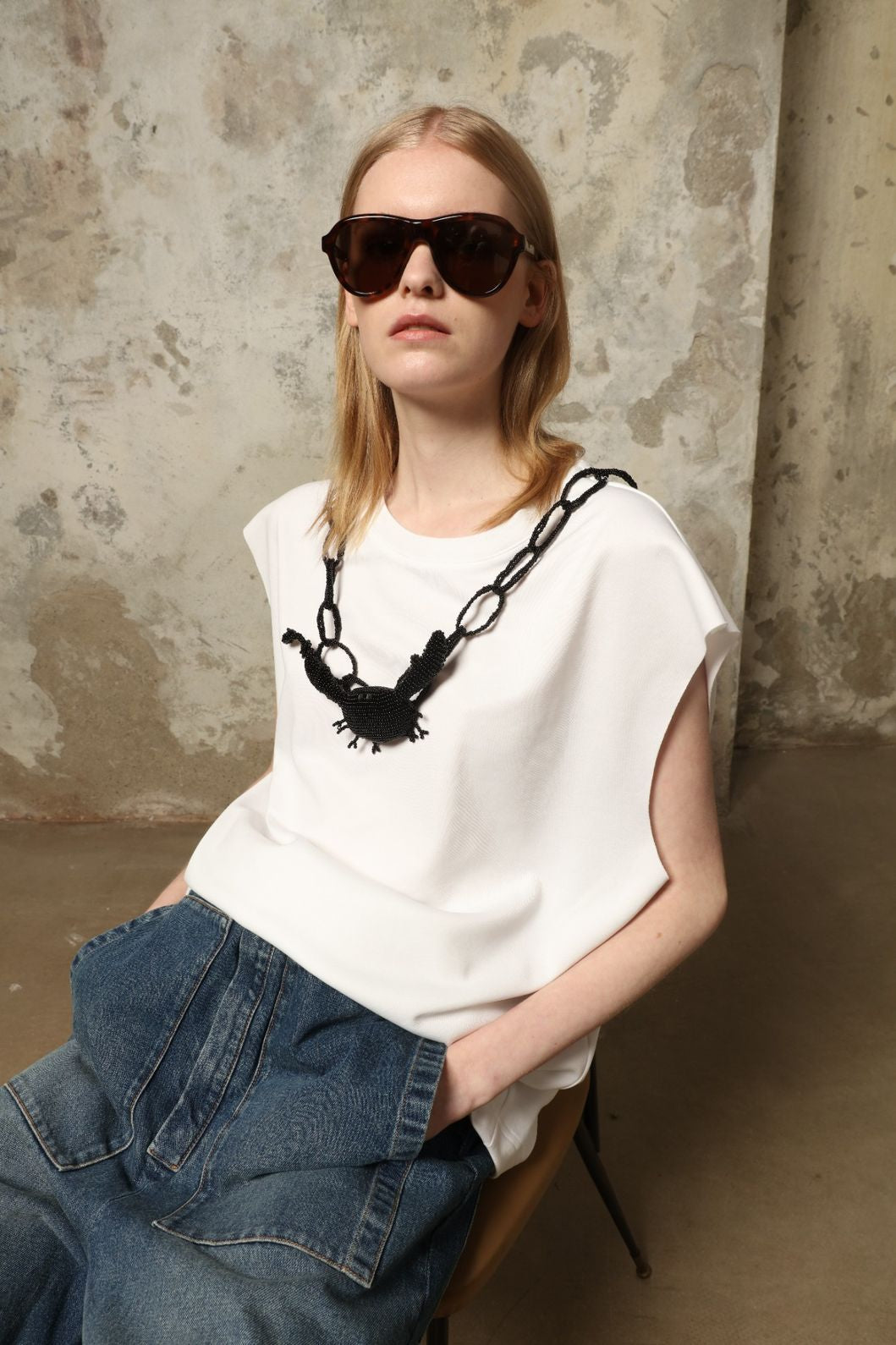 Model is wearing the Tea Cotton Jersey T-Shirt with Black Crab by Maison Jejia, a relaxed cotton tee featuring a playful beaded crab necklace detail, curated in the House of Woven Stories selection.