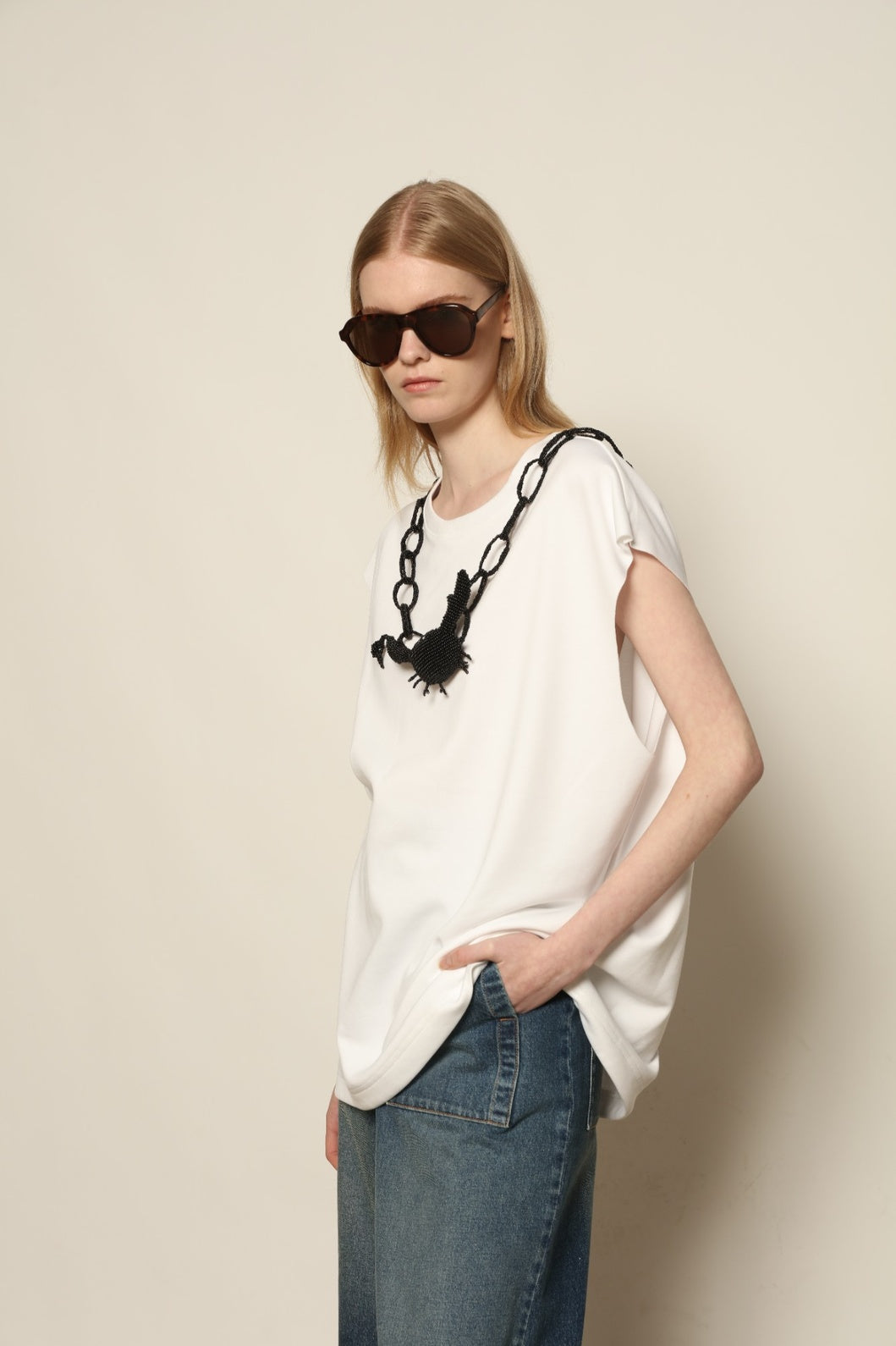 Model is wearing the Tea Cotton Jersey T-Shirt with Black Crab by Maison Jejia, a relaxed cotton tee featuring a playful beaded crab necklace detail, curated in the House of Woven Stories selection.