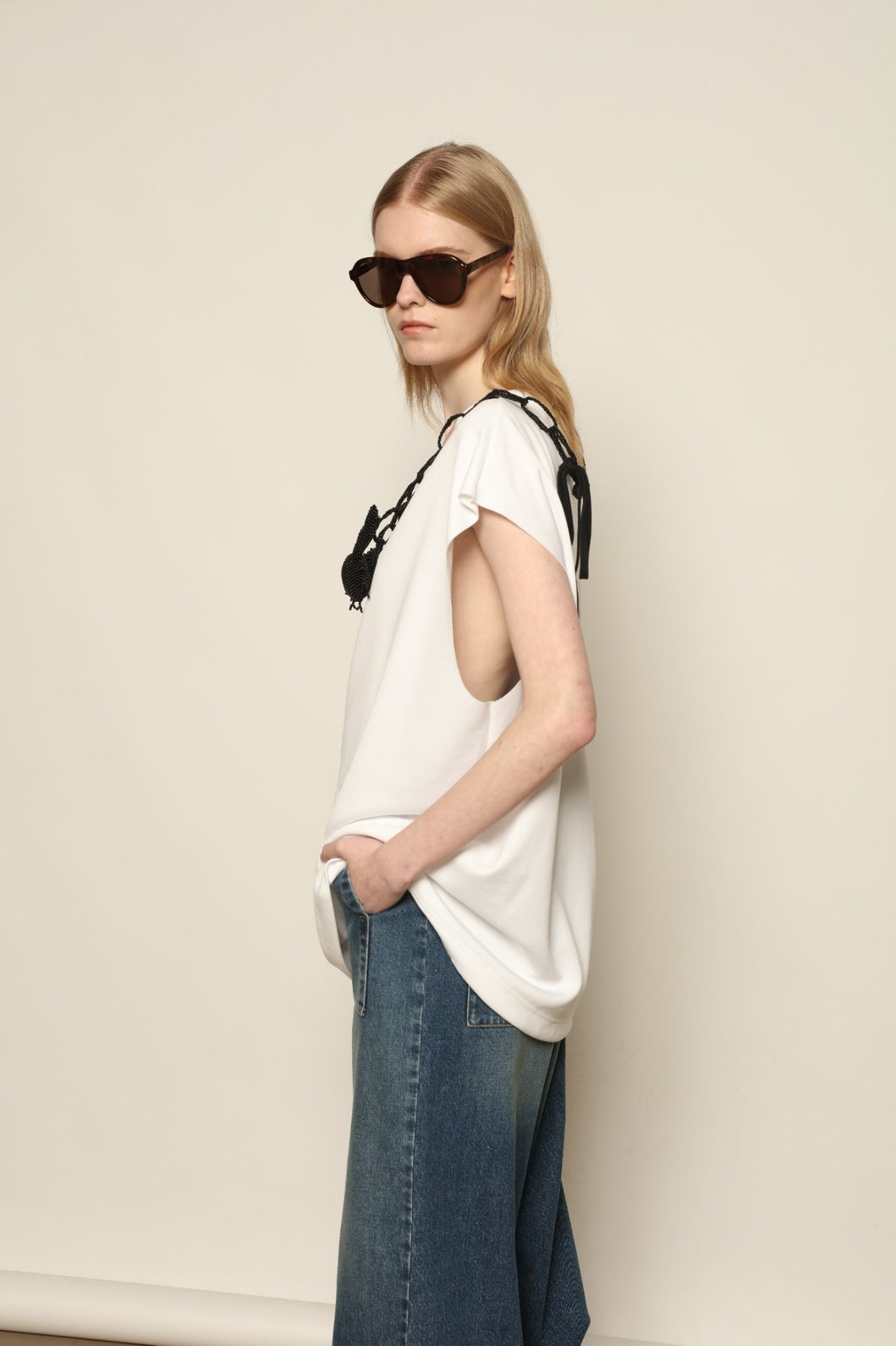 Model is wearing the Tea Cotton Jersey T-Shirt with Black Crab by Maison Jejia, a relaxed cotton tee featuring a playful beaded crab necklace detail, curated in the House of Woven Stories selection.