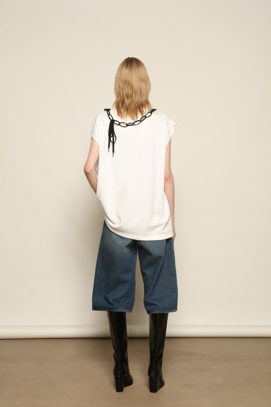 Model is wearing the Tea Cotton Jersey T-Shirt with Black Crab by Maison Jejia, a relaxed cotton tee featuring a playful beaded crab necklace detail, curated in the House of Woven Stories selection.