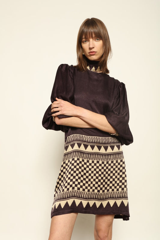 Model is wearing the Malaga Short Silk Dress with Belt by House of Woven Stories, hand-printed in Ajrakh silk with balloon sleeves and a waist belt.