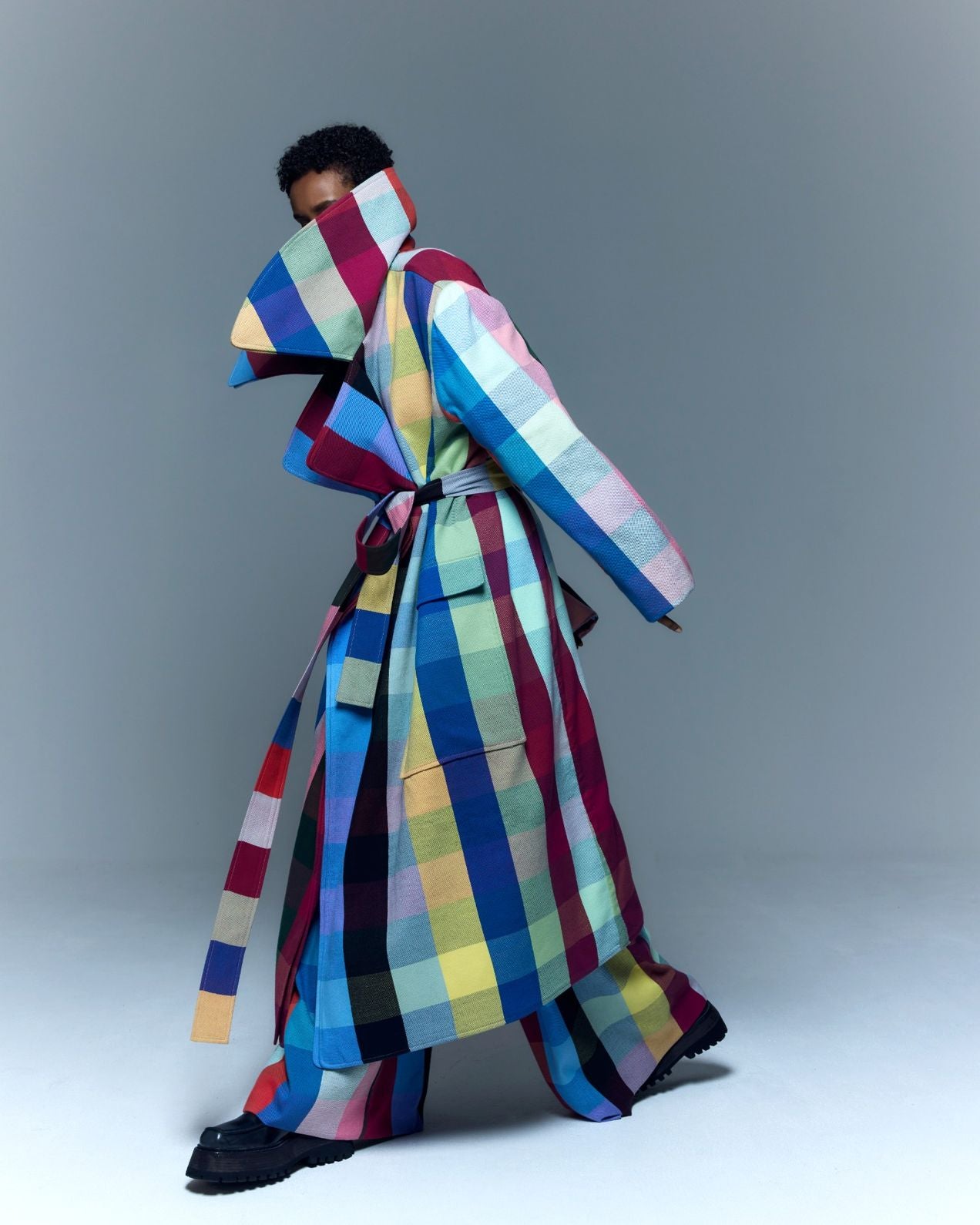 Model is wearing the Double Lapel Overcoat by Marrakshi Life, a hand-woven cotton bouclé coat with oversized plaid, sculptural double lapel and tie belt, curated in the House of Woven Stories selection.