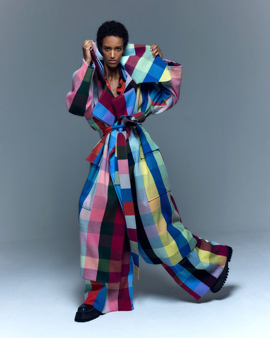 Model is wearing the Double Lapel Overcoat by Marrakshi Life, a hand-woven cotton bouclé coat with oversized plaid, sculptural double lapel and tie belt, curated in the House of Woven Stories selection.