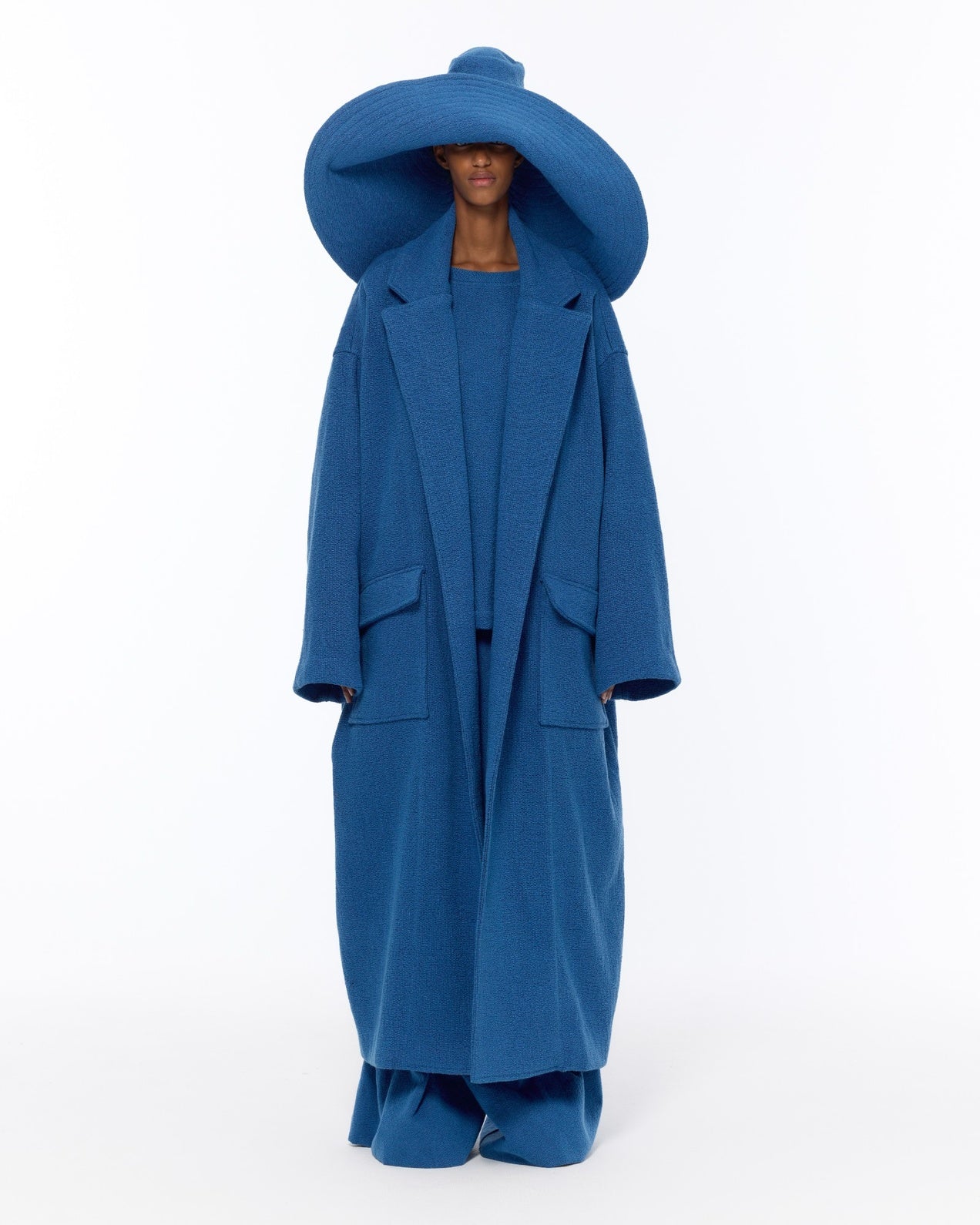 Model is wearing the French Blue Bouclé Blanket Coat by Marrakshi Life, a hand-woven oversized cotton bouclé coat with a deep shawl collar and textured finish, curated in the House of Woven Stories selection.